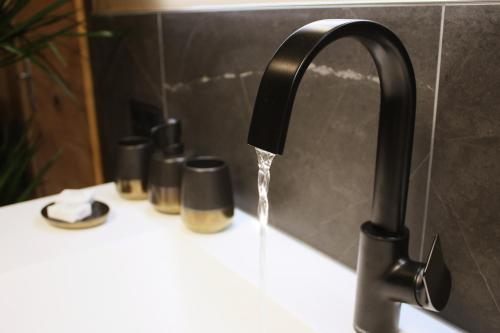 a bathroom sink with water running from a faucet at Boutique-Pension Jägerwirt in Scheffau am Wilden Kaiser