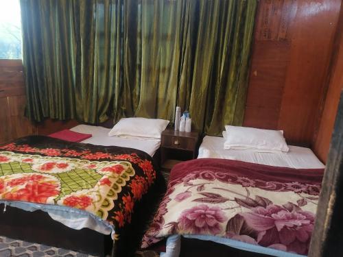a hotel room with two beds and curtains at Jungle Crown Organic Homestay in Nagarkot