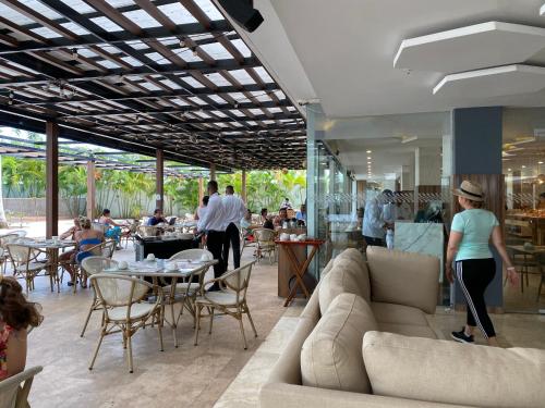 a restaurant with couches and tables and people eating at Playa Boquilla - Boquilla Beach - Apto con servicios de Hotel Sonesta in Cartagena de Indias