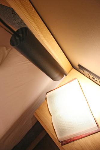 an open book on a table next to a lamp at Boutique-Pension Jägerwirt in Scheffau am Wilden Kaiser