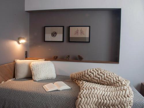 um quarto com uma cama com um cobertor e um livro em Villa Cam In Ski em Duszniki Zdrój