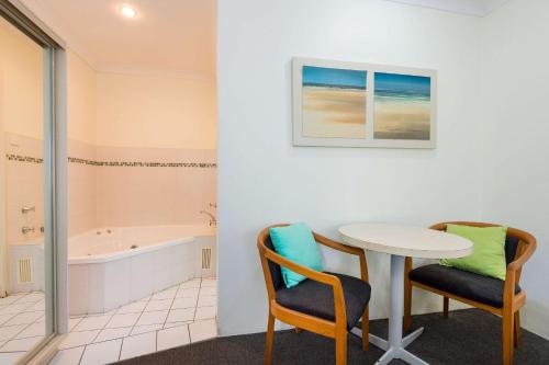 een badkamer met een tafel en stoelen en een bad bij Comfort Inn All Seasons in Ballina