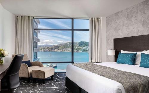 a hotel room with a bed and a large window at Rydges Wellington in Wellington