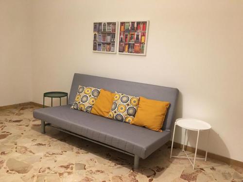Un sofá gris con dos almohadas amarillas en una habitación. en Tizi Apartments, en Maiori