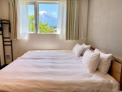 a bedroom with a large bed with a window at Megu fuji 2021 - Vacation STAY 74532v in Fujiyoshida