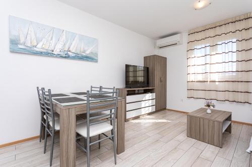 a kitchen and dining room with a table and chairs at Apartments Crnekovic Tomislava 8 in Baška