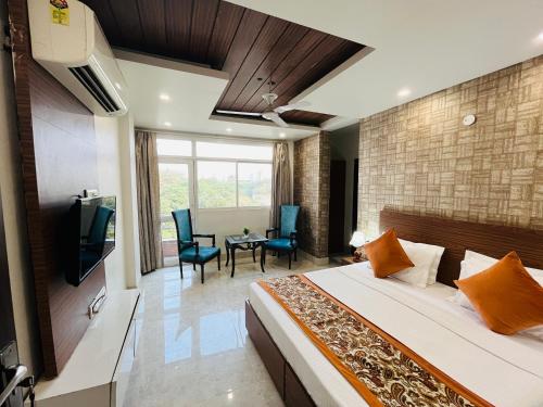 a bedroom with a bed and a television and a table at Hotel Dayal Regency, Shushant Lok sector 29, Near Fortis Hospital in Gurgaon