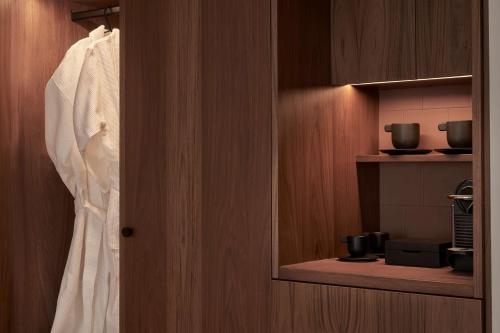 a closet with a white shirt hanging in a room at The Social Athens Hotel, a member of Radisson Individuals in Athens