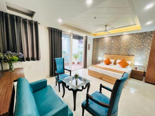 a bedroom with a bed and a couch and a table at Hotel Dayal Regency, Shushant Lok sector 29, Near Fortis Hospital in Gurgaon