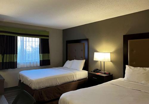 een hotelkamer met twee bedden en een raam bij Econo Lodge Spring Lake near Fort Bragg in Spring Lake