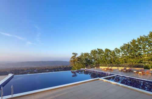 a house with a swimming pool with a view at Rakkh Resort, a member of Radisson Individuals Retreats in Pālampur