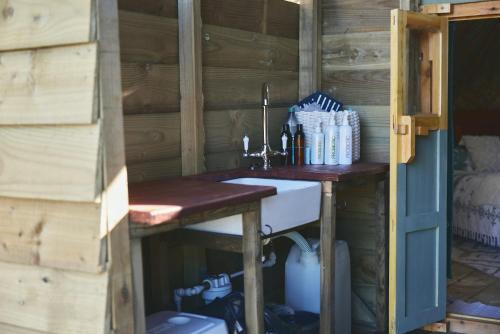 a bathroom with a sink in a wooden cabin at Raven Yurt - Yurtopia in Aberystwyth