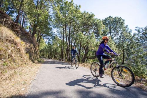 a couple of people riding bikes down a road at Rakkh Resort, a member of Radisson Individuals Retreats in Pālampur