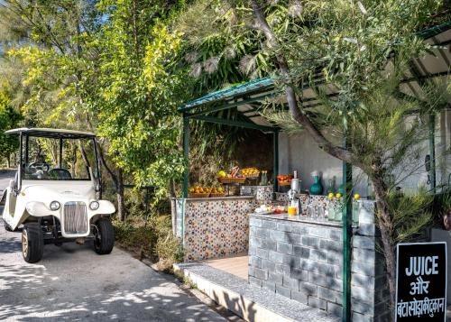 an old car parked in front of a fruit stand at Rakkh Resort, a member of Radisson Individuals Retreats in Pālampur