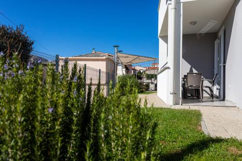 a house with a fence and a chair on a porch at Apartments Crnekovic Tomislava 8 in Baška