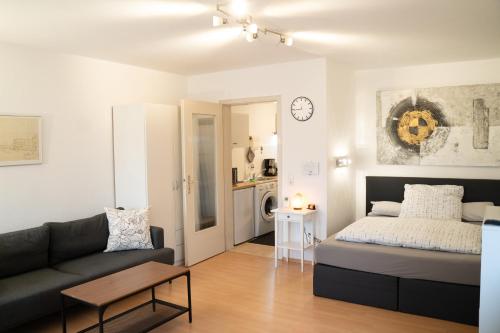 a living room with a bed and a couch at Apartment und WG-Doppelzimmer Sonnenhalde in Tübingen