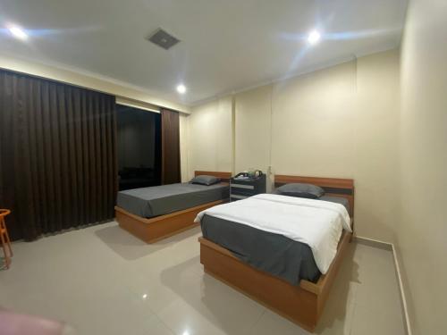 1 dormitorio con 2 camas y ventana en MAHANAIM HOTEL, 