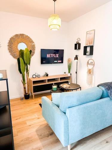 un salon avec un canapé bleu et une télévision dans l'établissement Nouveau ** Le raffiné au cœur de Guingamp ** Parking, à Guingamp