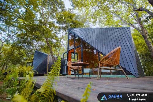 a house with a metal roof and chairs on a deck at Gabaa Resort & Spa - Habarana in Habarana