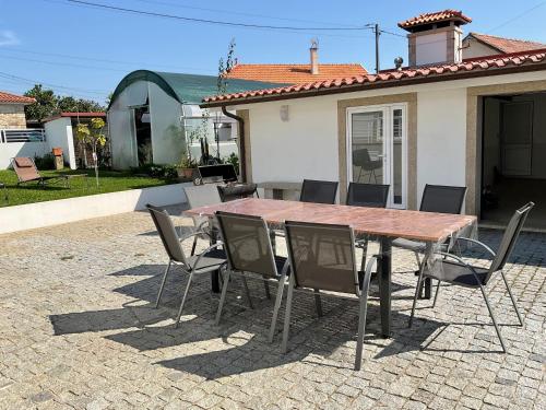 ein Holztisch und Stühle vor einem Haus in der Unterkunft CRALS - Casa da Guilheta in Esposende