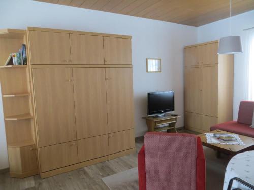 ein Wohnzimmer mit einem großen Schrank und einem TV in der Unterkunft Sport Alpin Wohnung 1 in Oberstdorf