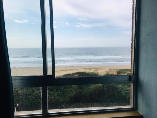 a view of the beach from a window at Amanzimtoti Afsaal Holiday Letting in Amanzimtoti