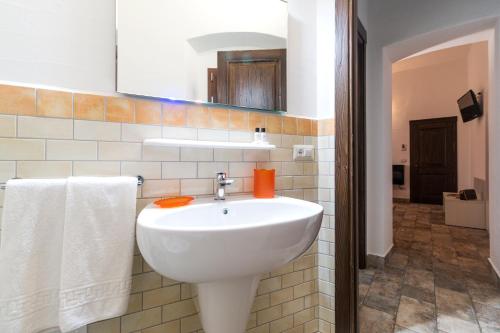 a bathroom with a white sink and a mirror at Karama in Dorgali