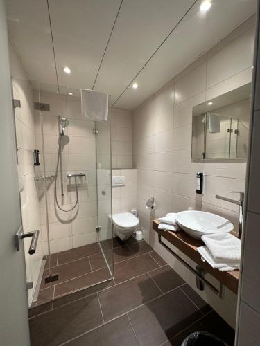 a bathroom with a shower and a toilet and a sink at Residence am Marktplatz in Interlaken