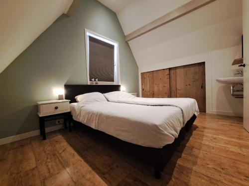 een slaapkamer met een groot bed en een raam bij Vakantiewoning 't Molenhuisje Westkapelle in Westkapelle