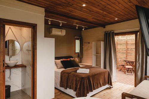 a bedroom with a bed and a patio at Pousada Colina Verde in Garopaba