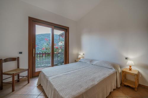 a bedroom with a bed and a window and a chair at La Paolina Vista Mare e Natura in Marciana Marina