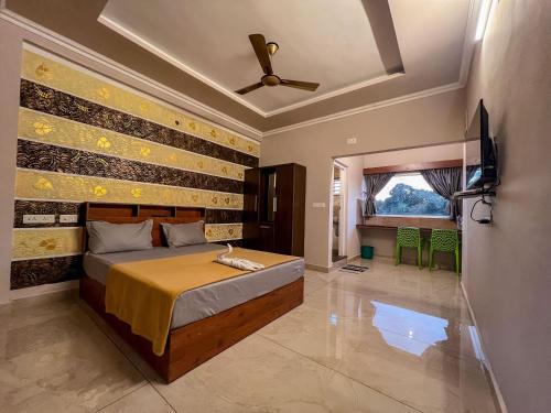 a bedroom with a bed and a television in it at Green Palace Resort in Vagamon