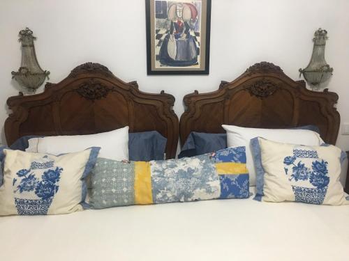 a bed with two wooden beds with pillows on it at Palacete Encanto Maior in Campo Maior