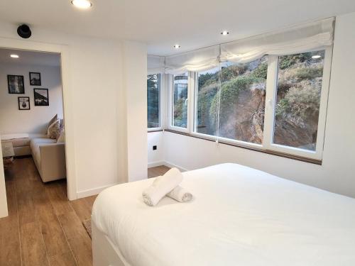1 dormitorio con cama y ventana grande en Brand New Appartment very cosy and awesome display close to the ski slope! private parking en Sierra Nevada