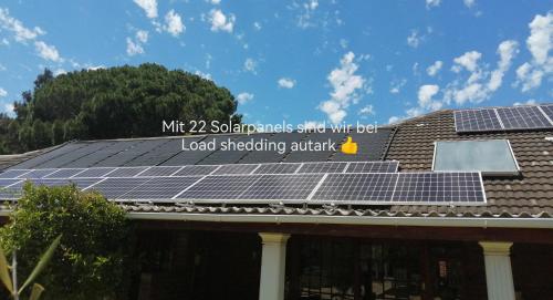 a group of solar panels on the roof of a house at Gästehaus HelderbergView in Somerset West