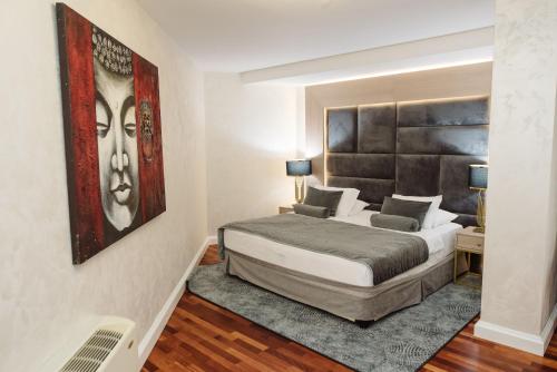 a bedroom with a bed and a painting on the wall at A Hoteli - Hotel Izvor in Arandjelovac