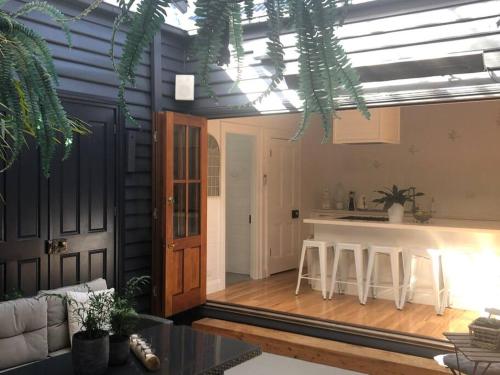 a living room with a kitchen and a table at Driftwood Beach House in Kiama