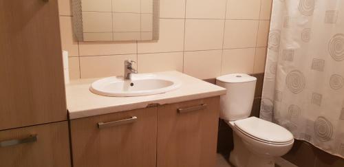 a bathroom with a sink and a toilet and a mirror at Mazotos Panoramic Village in Mazotos