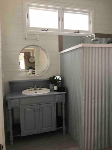 a bathroom with a sink and a mirror at Driftwood Beach House in Kiama