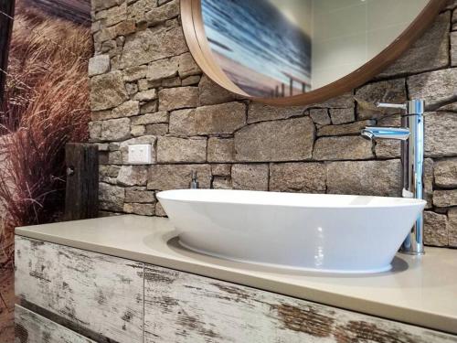 a bathroom with a white sink and a mirror at Driftwood Beach House in Kiama