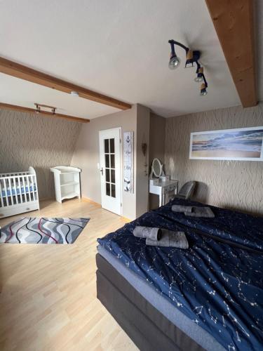 Schlafzimmer mit einem Bett mit blauer Decke in der Unterkunft Ferienhaus Markus - Grömitz OT Brenkenhagen in Grömitz