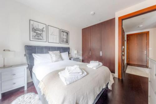 a bedroom with a large bed with towels on it at Stylish 1 Bedroom Flat in Nine Elms in London