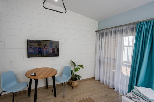 a living room with a table and chairs and a window at Halfarock Vízi-Erdei Apartmanház in Levelek
