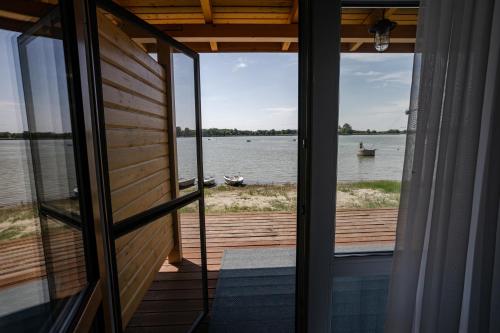 a room with a view of the water from a house at Halfarock Vízi-Erdei Apartmanház in Levelek