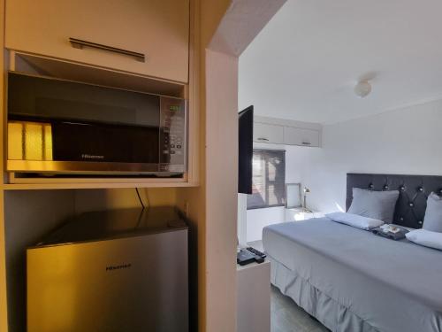 1 dormitorio con 1 cama y microondas en una habitación en Casa-Pel Guest Wing, en Palapye