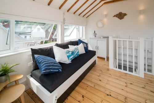 een woonkamer met een bank met kussens erop bij Blue Winds and Waves in Cowes