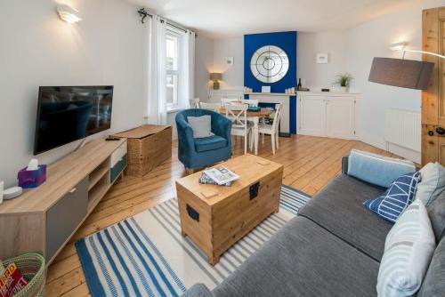 a living room with a couch and a table at Blue Winds and Waves in Cowes