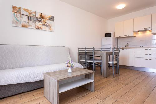 a living room with a couch and a table at Apartments Crnekovic Tomislava 8 in Baška
