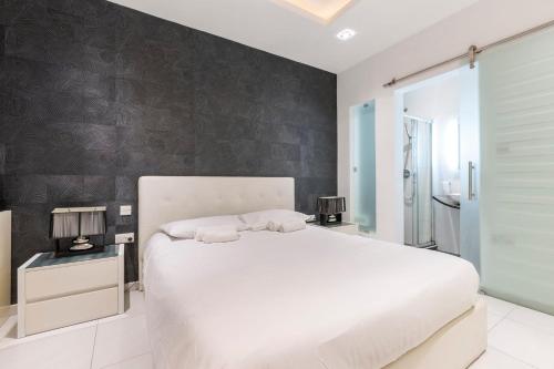una camera con un letto bianco e una parete nera di BLUEMARINE Suite-Hosted by Sweetstay a San Giuliano
