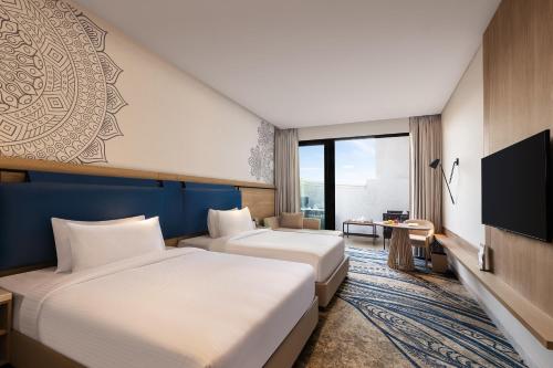 um quarto de hotel com duas camas e uma televisão de ecrã plano em Fortune Walkway Mall, Haldwani - Member ITC's Hotel Group em Haldwani